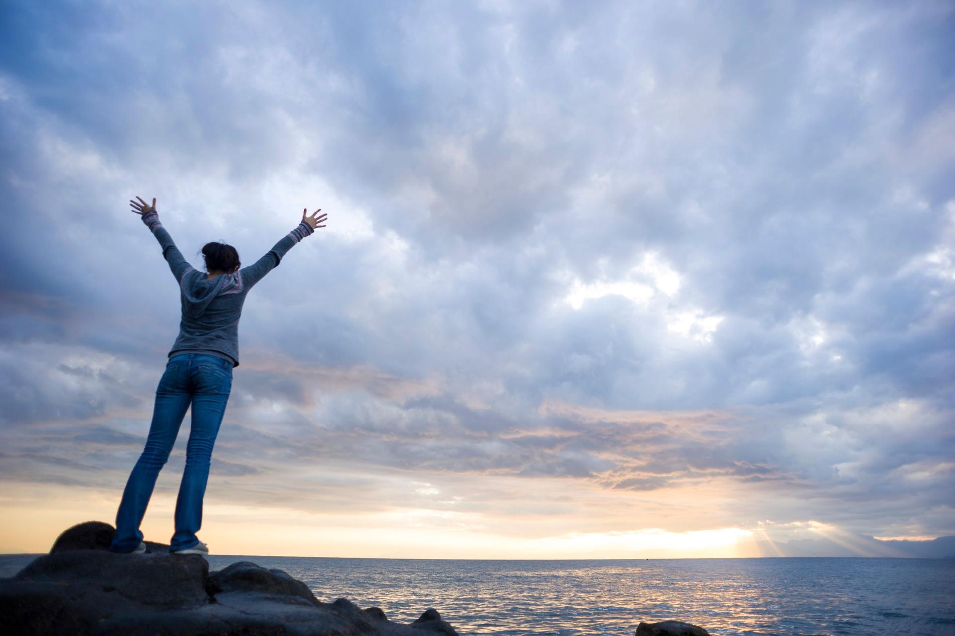 Victory - a lady with her back to us reaching for the sky with her arms out in sheer happiness