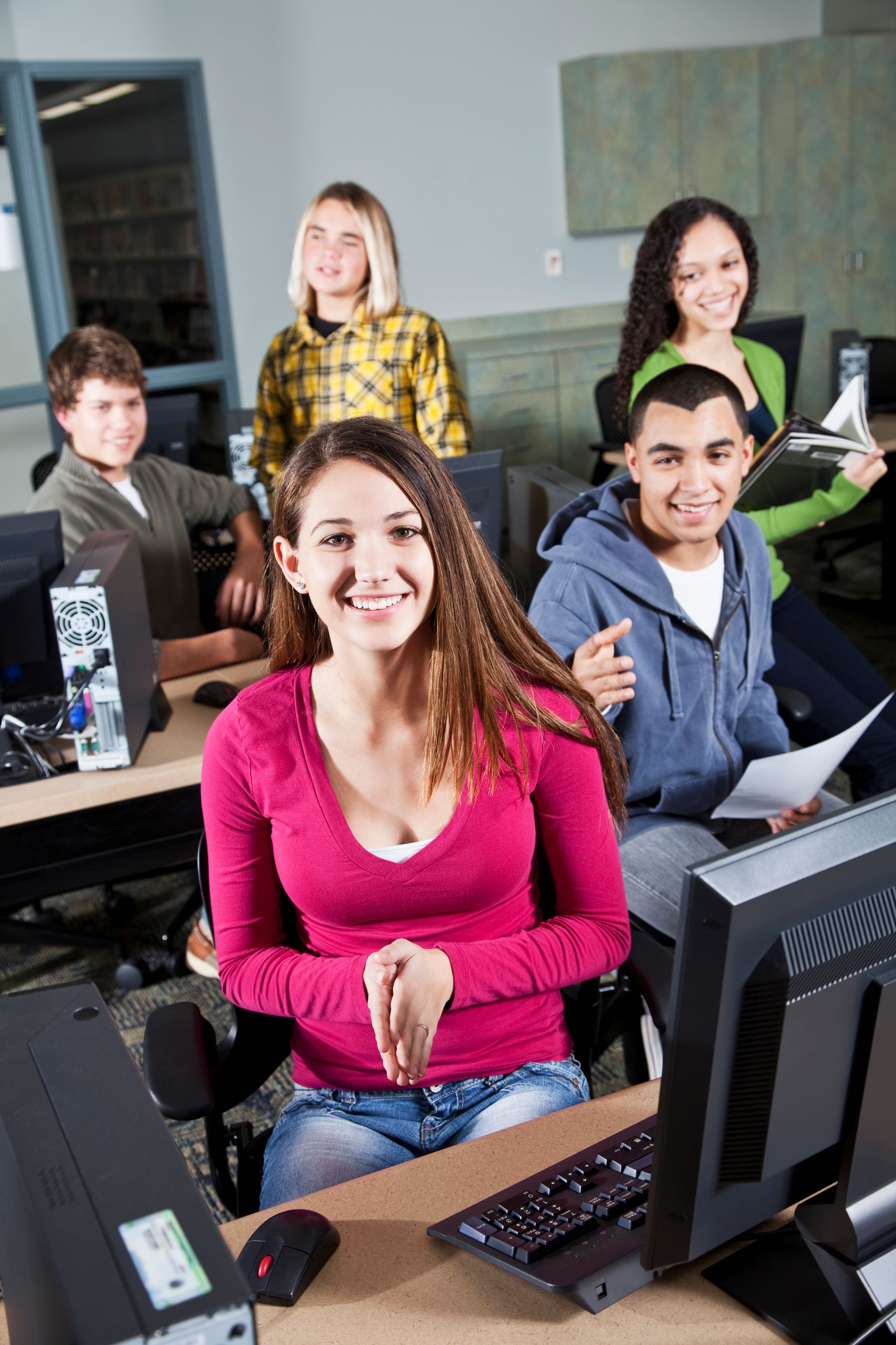 Teenage students in computer lab happy and smiling at the camera