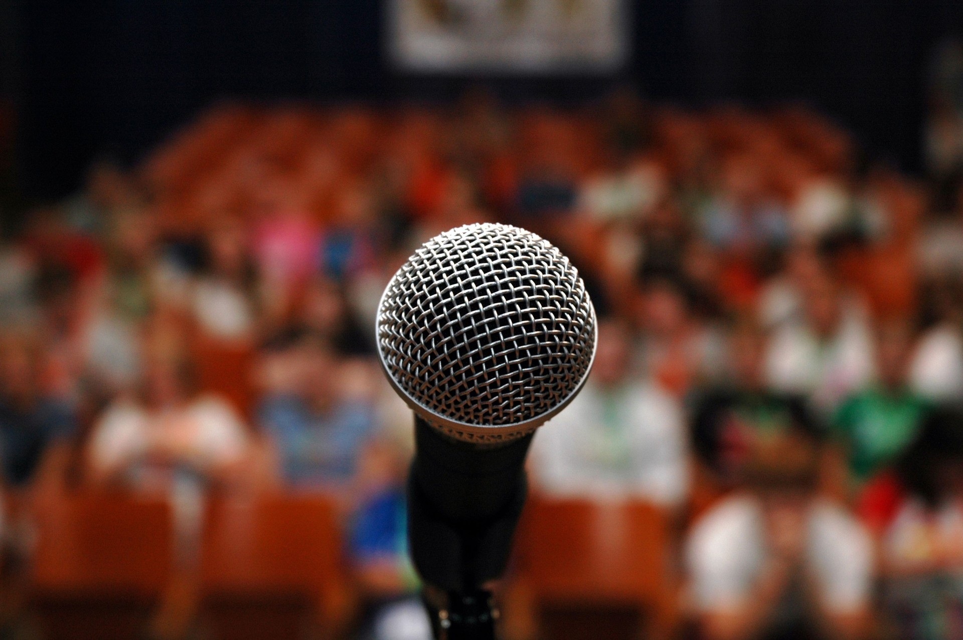 lens focus on Microphone in front of a crowd - Implying Stage Fright